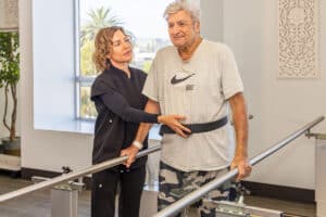 A rehab therapist with a resident in the rehab gym at Beachwood Post-Acute and Rehab