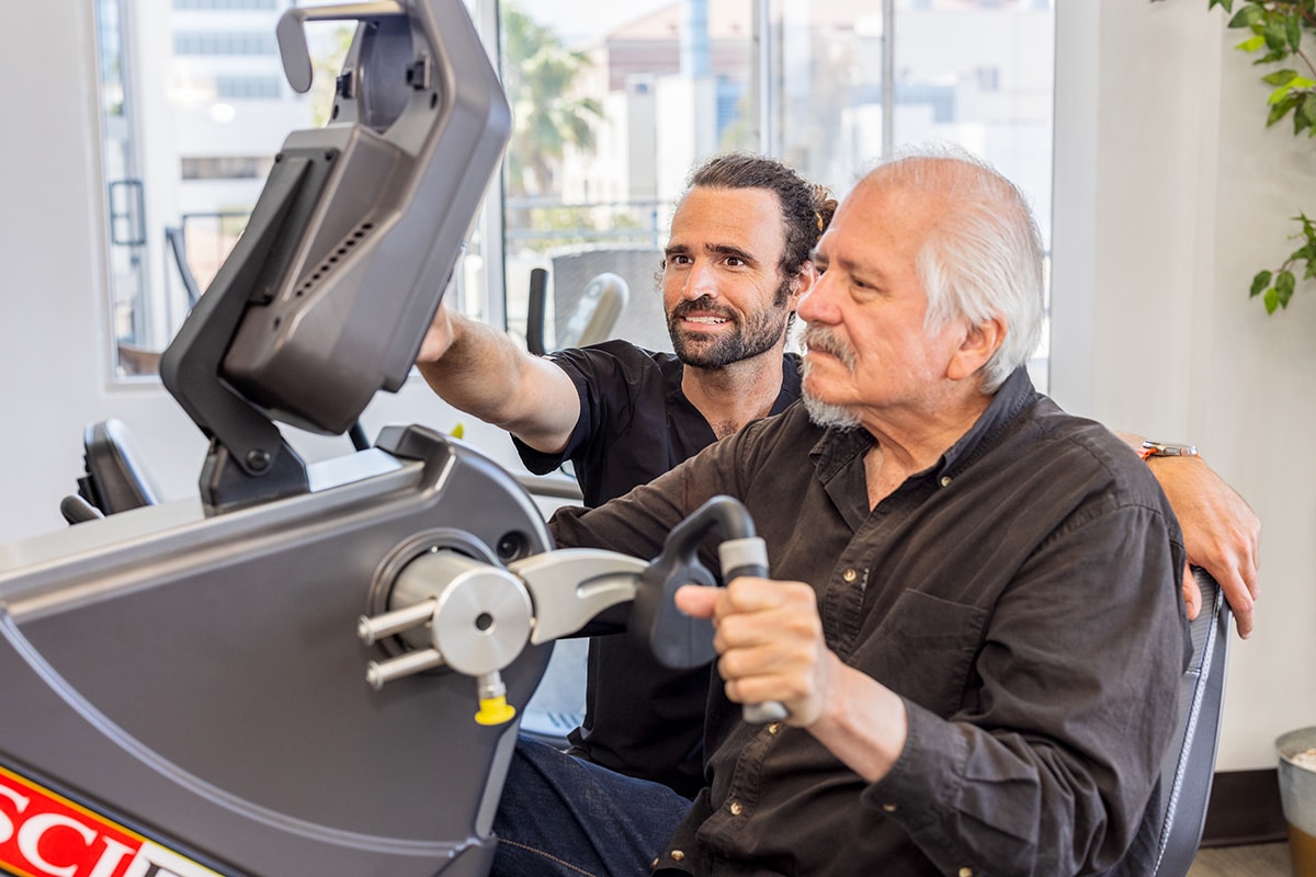 A male rehab therapist with a resident in the rehab gym at Beachwood Post-Acute and Rehab