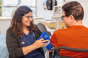 A nurse taking the blood pressure of a resident at Beachwood Post-Acute and Rehab